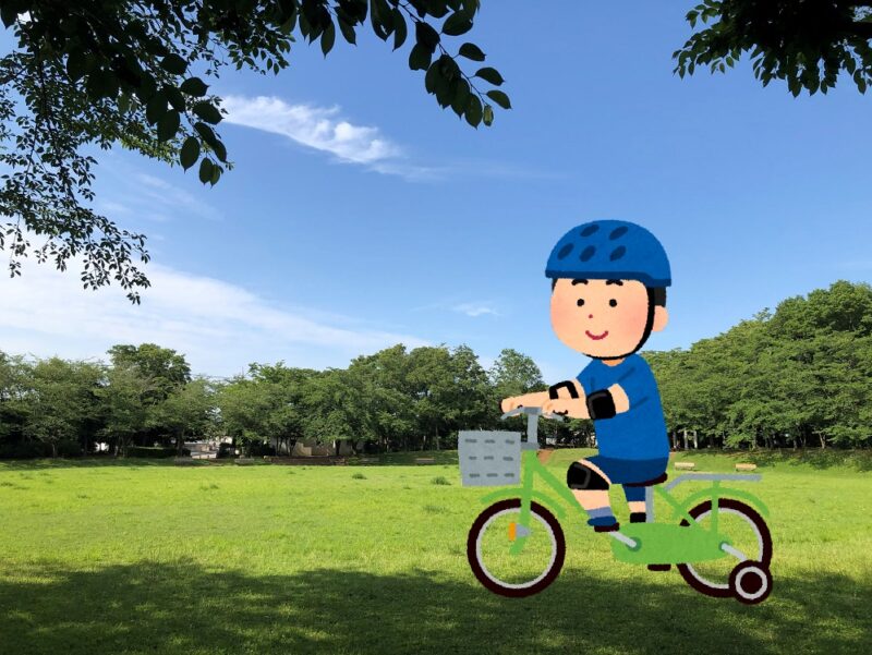 補助輪付き自転車で公園を走る